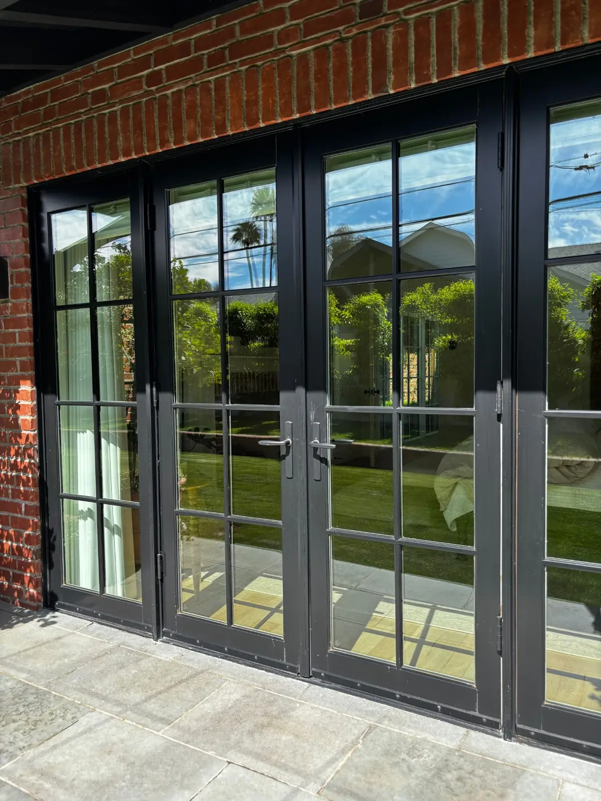 Crystal-clear black French doors on a brick home