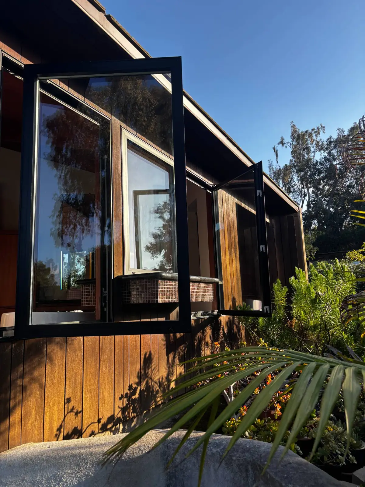 Clean casement window on a wood-sided home